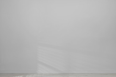 Photo of Empty room with white wall and wooden floor