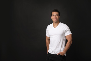Photo of Handsome young African-American man on black background. Space for text