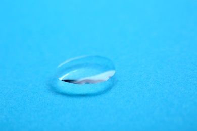 Photo of Pure water drop on color background, closeup