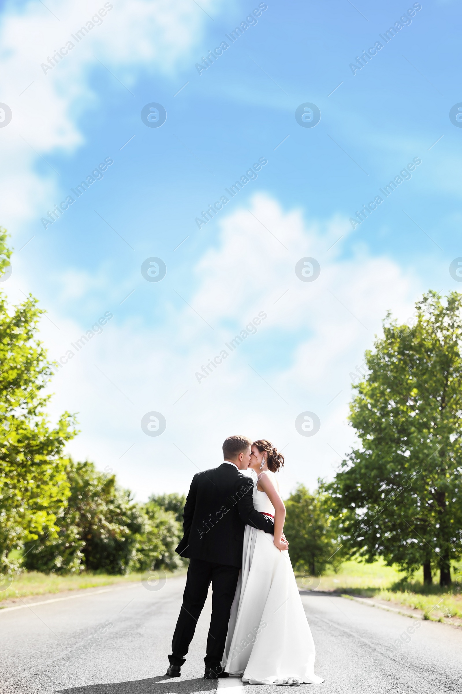 Photo of Bride and her groom kissing on highway