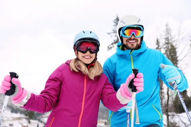 Photo of Couple of skiers on slope at resort. Winter vacation