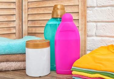 Photo of Clean clothes, towels and detergents on table