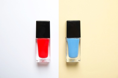 Photo of Bottles of nail polish on color background, top view