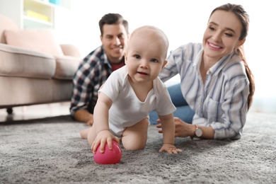 Photo of Adorable little baby crawling near parents at home