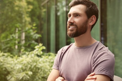 Portrait of handsome bearded man outdoors, space for text