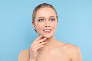 Photo of Portrait of young woman with beautiful face on blue background