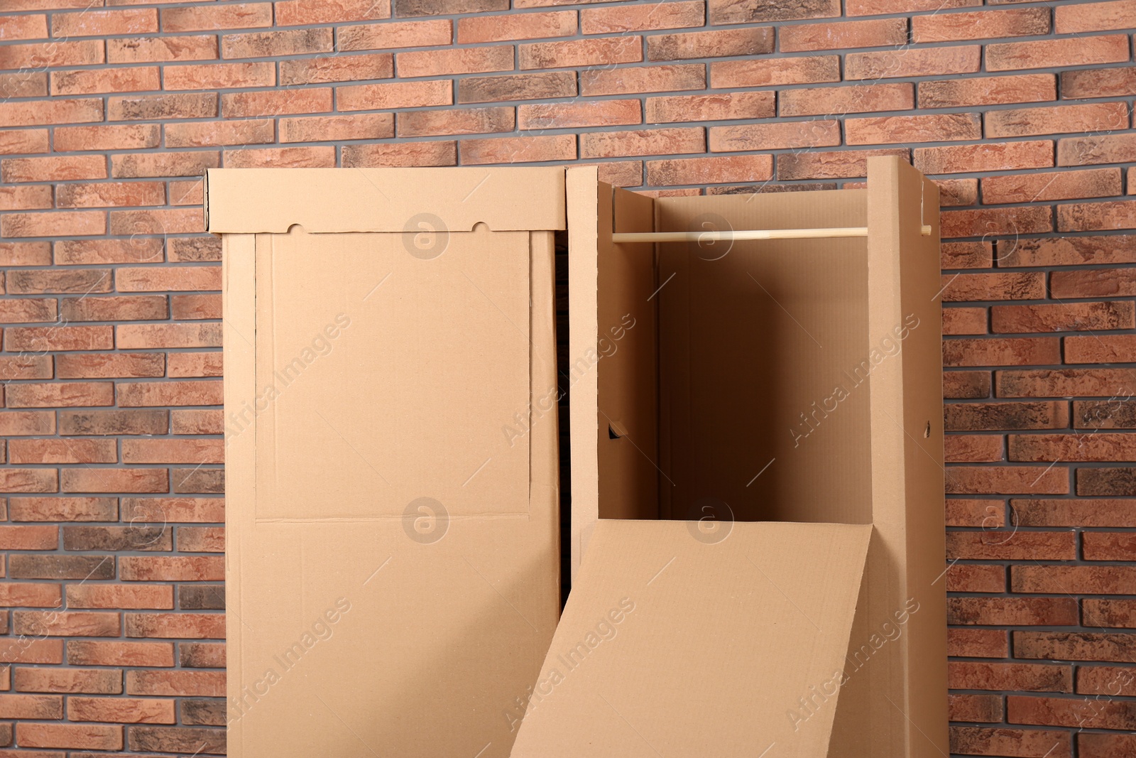 Photo of Empty cardboard wardrobe boxes against brick wall