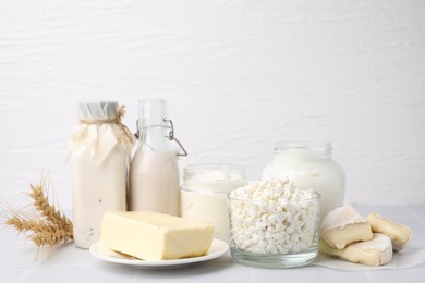 Photo of Different dairy products and spikes on white table