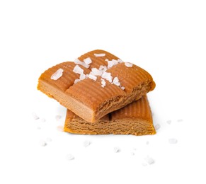 Photo of Yummy caramel candies and sea salt isolated on white