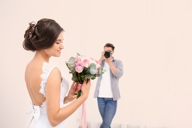 Photo of Professional photographer taking photo of beautiful bride in studio