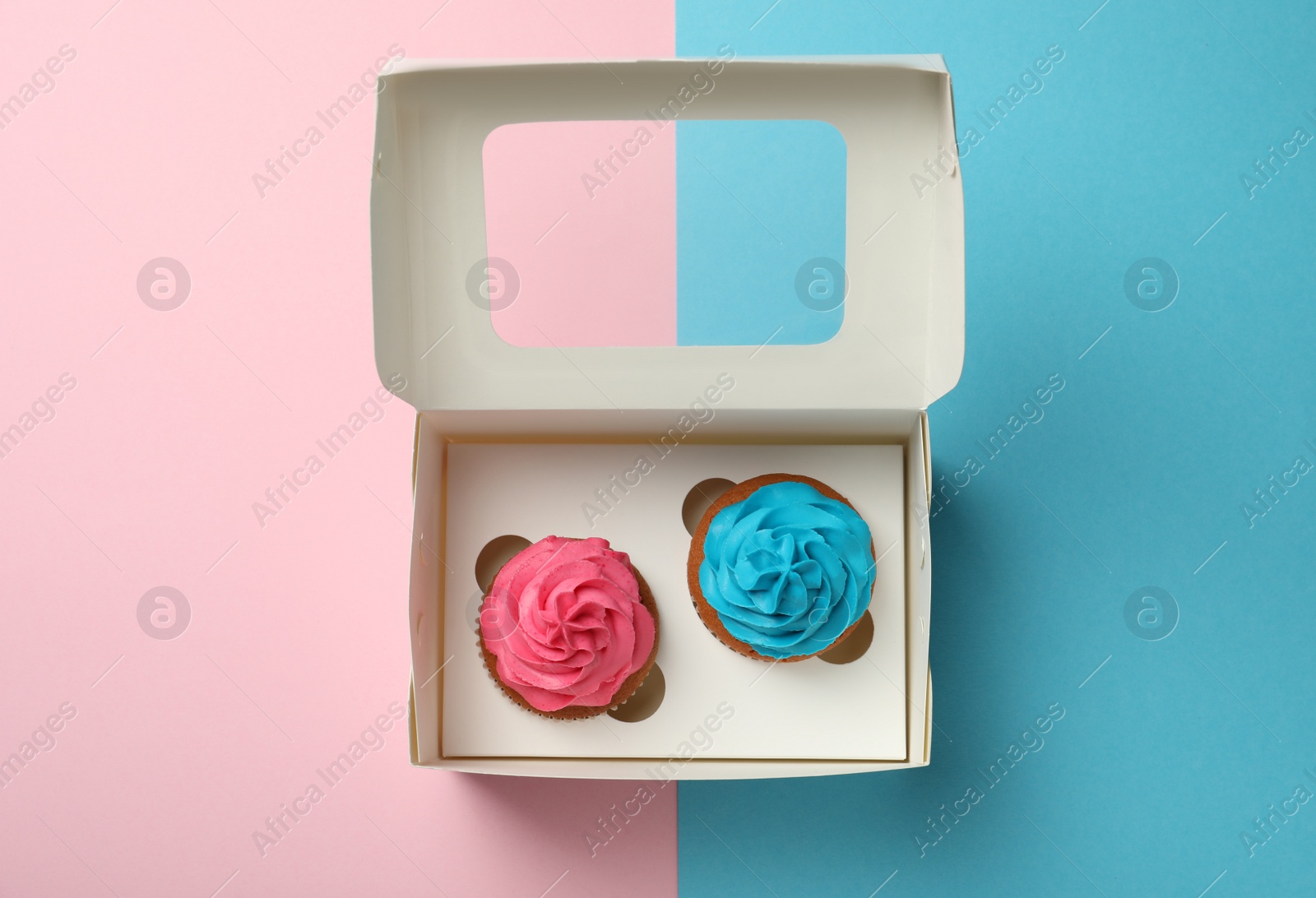 Photo of Box with different delicious cupcakes on color background, top view