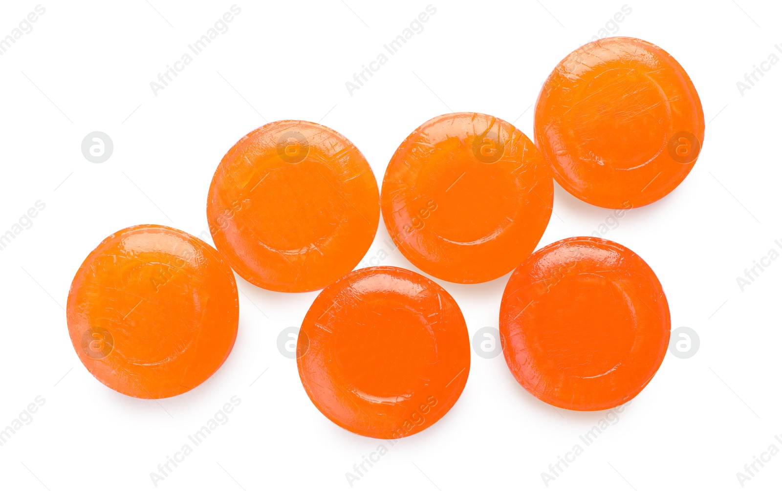 Photo of Many orange cough drops on white background, top view