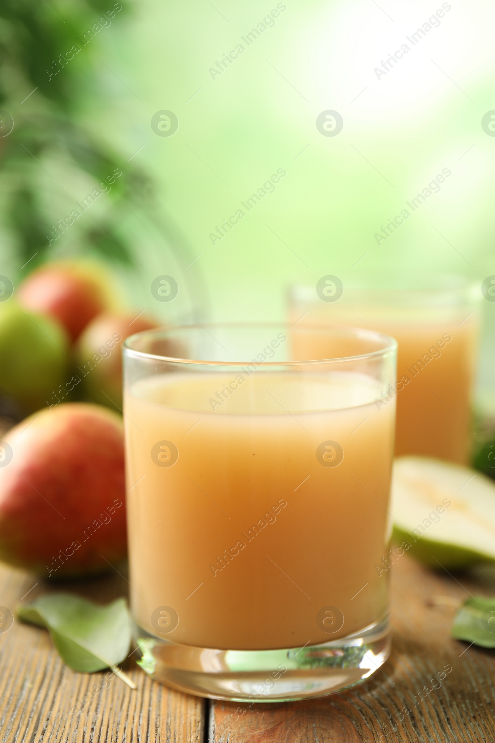 Photo of Fresh pear juice in glass on wooden table, closeup