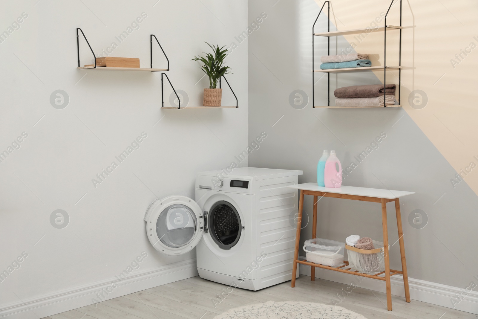 Photo of Modern washing machine in laundry room interior