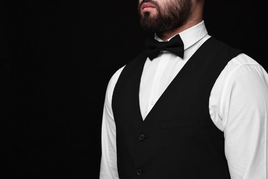 Photo of Man in shirt and bow tie on black background, closeup. Space for text