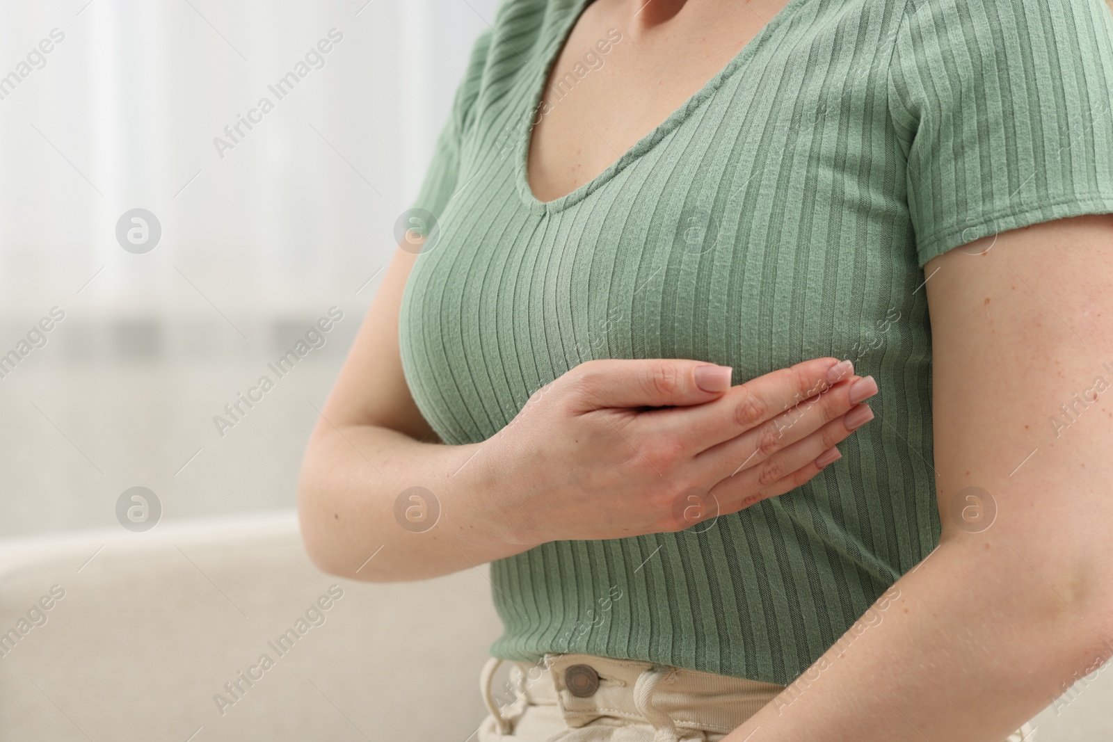 Photo of Mammology. Young woman doing breast self-examination at home, closeup