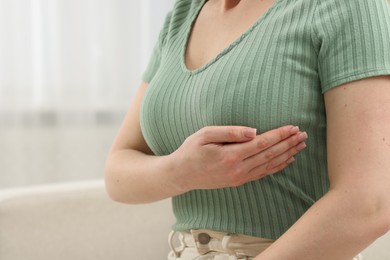 Photo of Mammology. Young woman doing breast self-examination at home, closeup