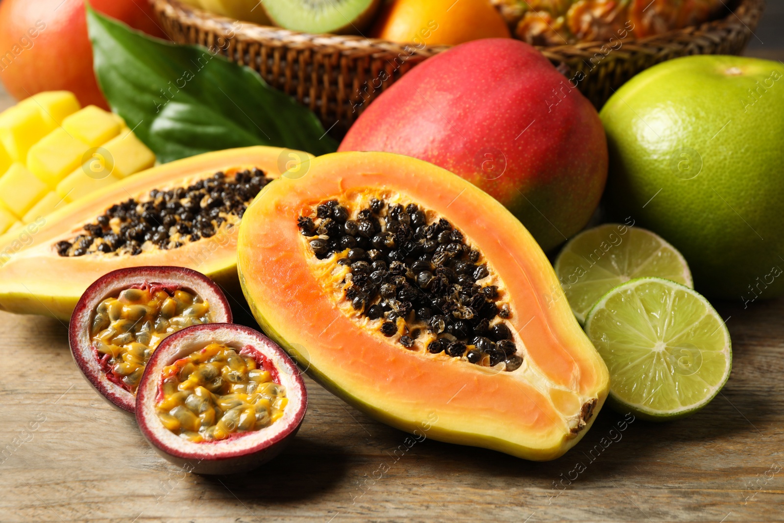 Photo of Fresh ripe papaya and other fruits on wooden table