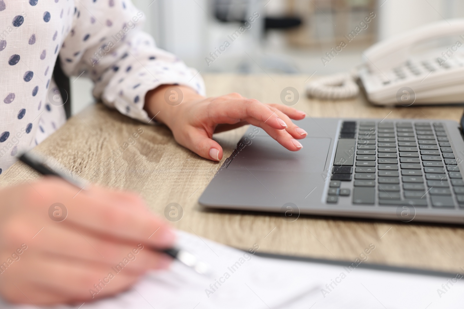 Photo of Secretary working at table in office, closeup