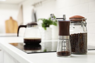 Photo of Manual coffee grinder and beans on counter in kitchen