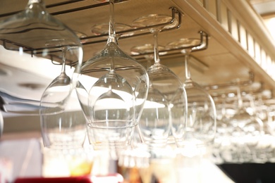 Set of empty clean glasses on bar racks