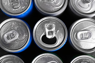 Photo of Energy drinks in wet cans as background, top view. Functional beverage