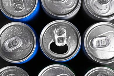 Energy drinks in wet cans as background, top view. Functional beverage