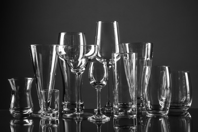 Empty glasses for different drinks on dark background