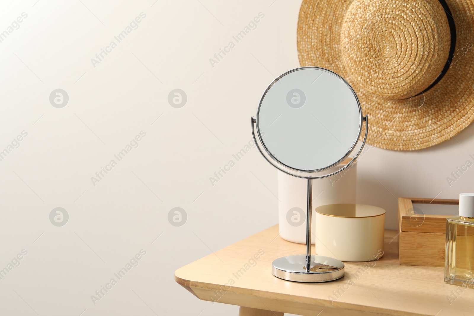 Photo of Mirror, perfume and accessories on makeup table in room. Space for text