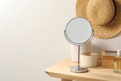 Mirror, perfume and accessories on makeup table in room. Space for text