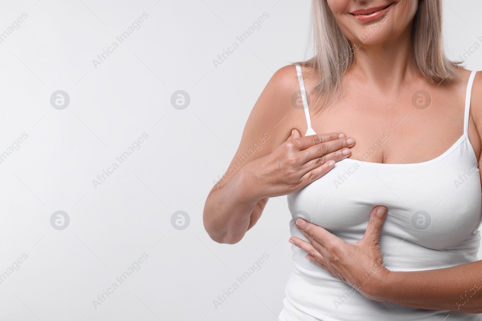 Photo of Woman doing breast self-examination on white background, closeup. Space for text