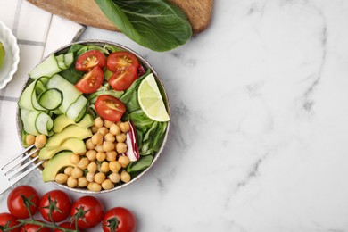 Photo of Tasty salad with chickpeas and vegetables served on white marble table, flat lay. Space for text