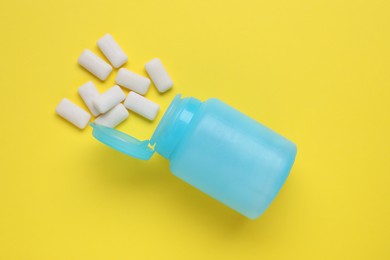 Photo of Jar with chewing gums on yellow background, flat lay