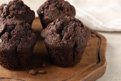 Photo of Delicious fresh chocolate muffins on white table, closeup. Space for text