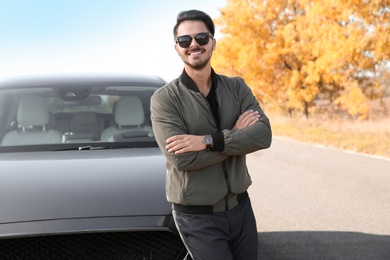 Young man near modern car on sunny day, outdoors