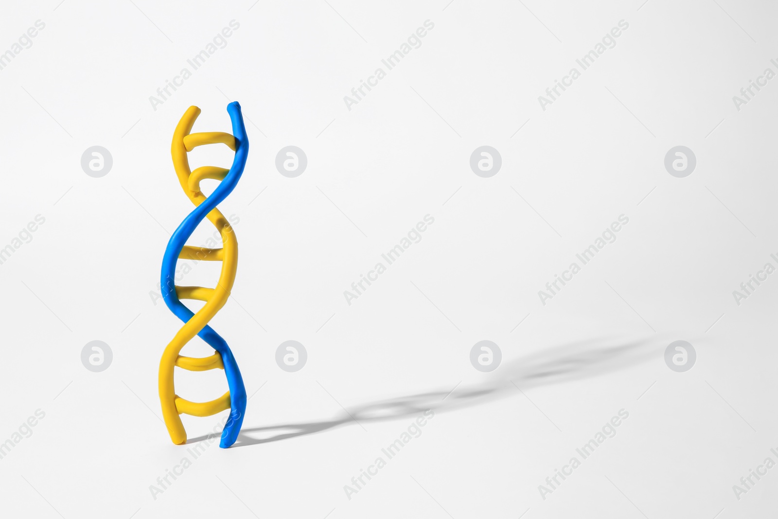 Photo of DNA molecule model made of colorful plasticine on white background, space for text