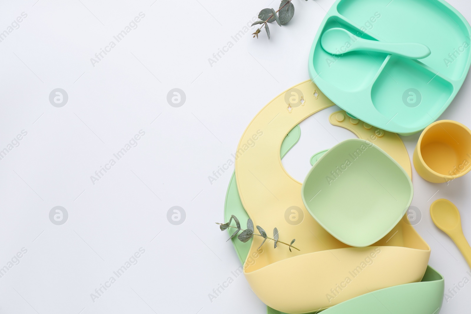 Photo of Composition with baby feeding accessories and bib on white background, top view. Space for text