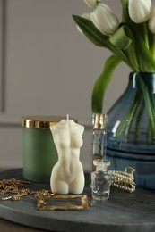 Beautiful female body shape candle, flowers and decor on table