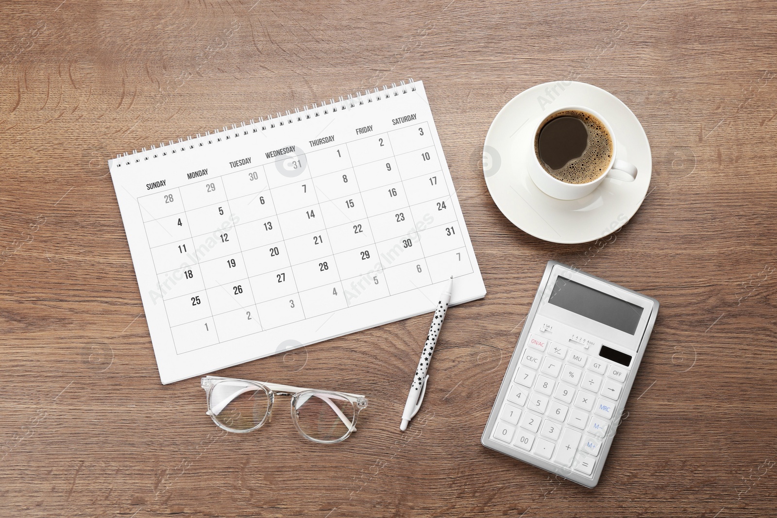 Photo of Flat lay composition with calendar and cup of coffee on wooden table