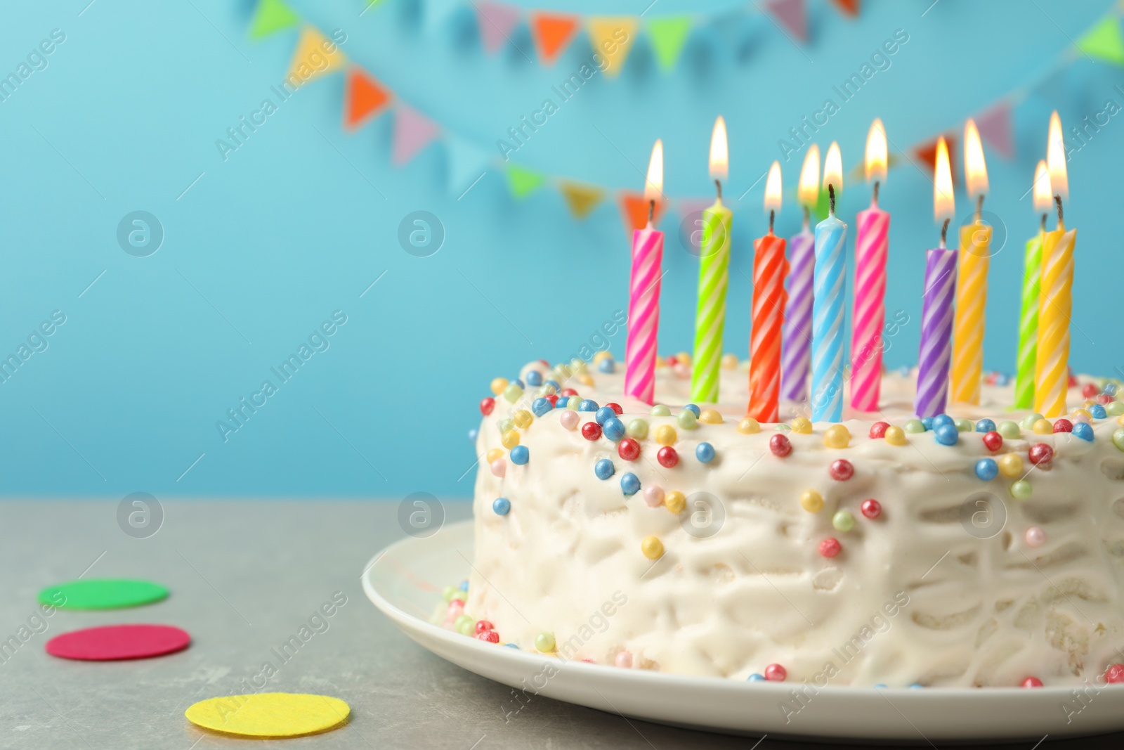 Photo of Delicious birthday cake with burning candles on table