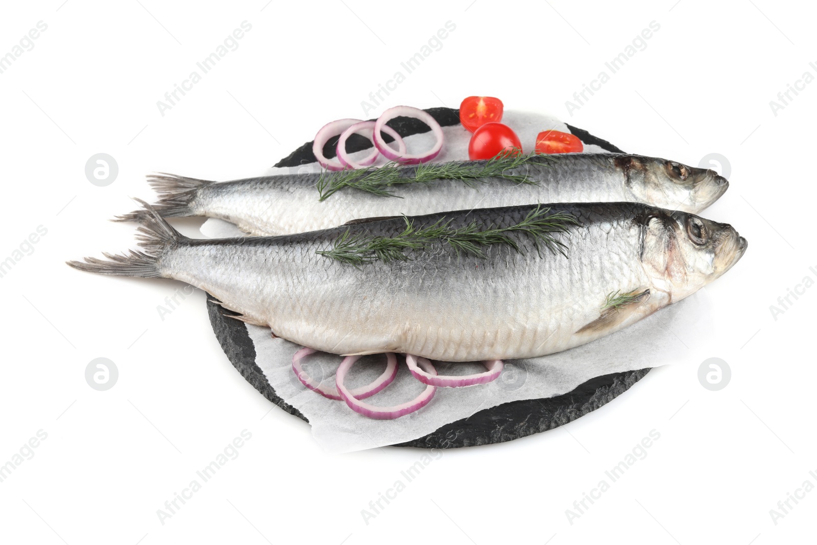 Photo of Slate plate with salted herrings, onion rings, dill and cherry tomatoes isolated on white