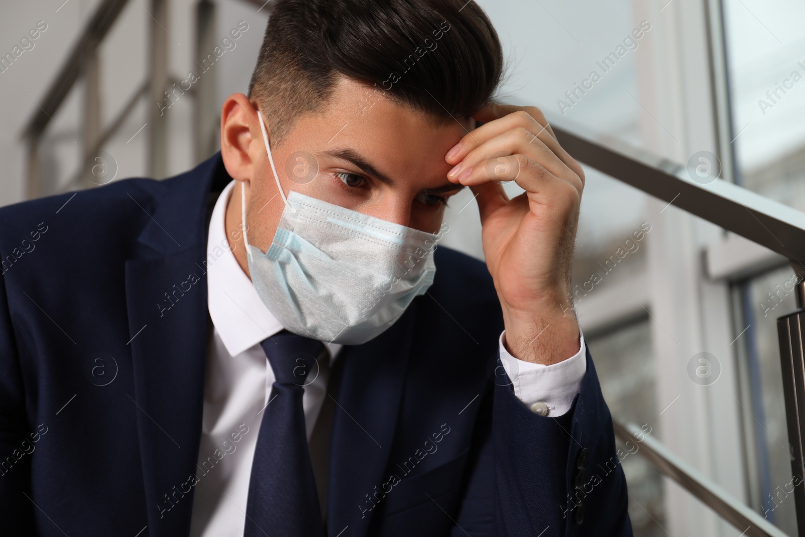 Photo of Sad man in protective mask indoors. Self-isolation during coronavirus pandemic