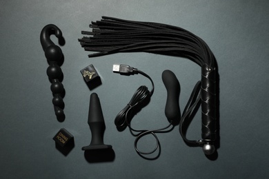 Different sex toys on dark background, flat lay
