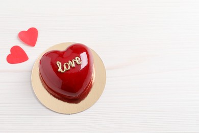 Photo of St. Valentine's Day. Delicious heart shaped cake and confetti on white wooden table, top view. Space for text