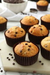 Photo of Delicious sweet muffins with chocolate chips on table, closeup