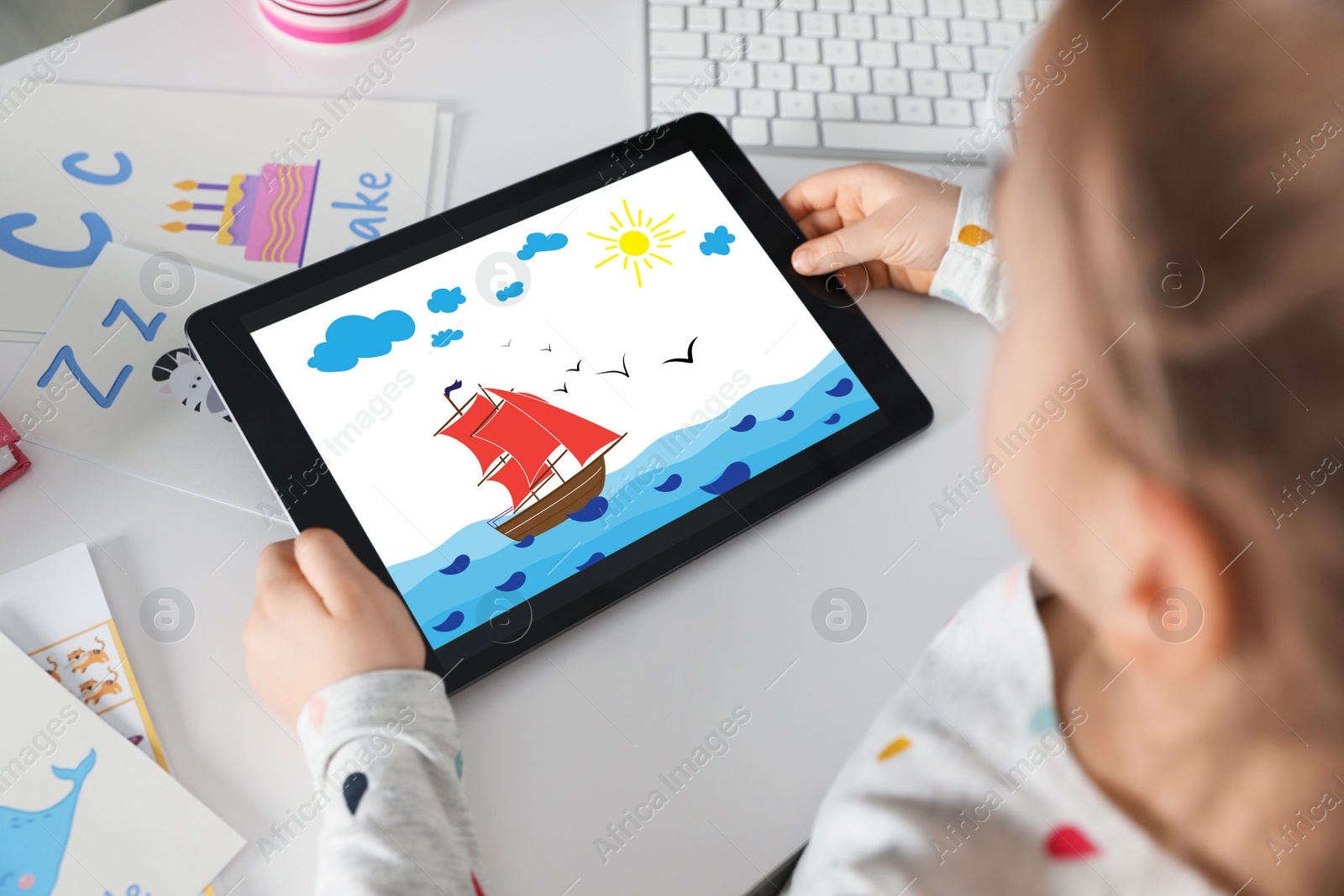 Image of Little girl holding tablet with cute drawing at home. Child art