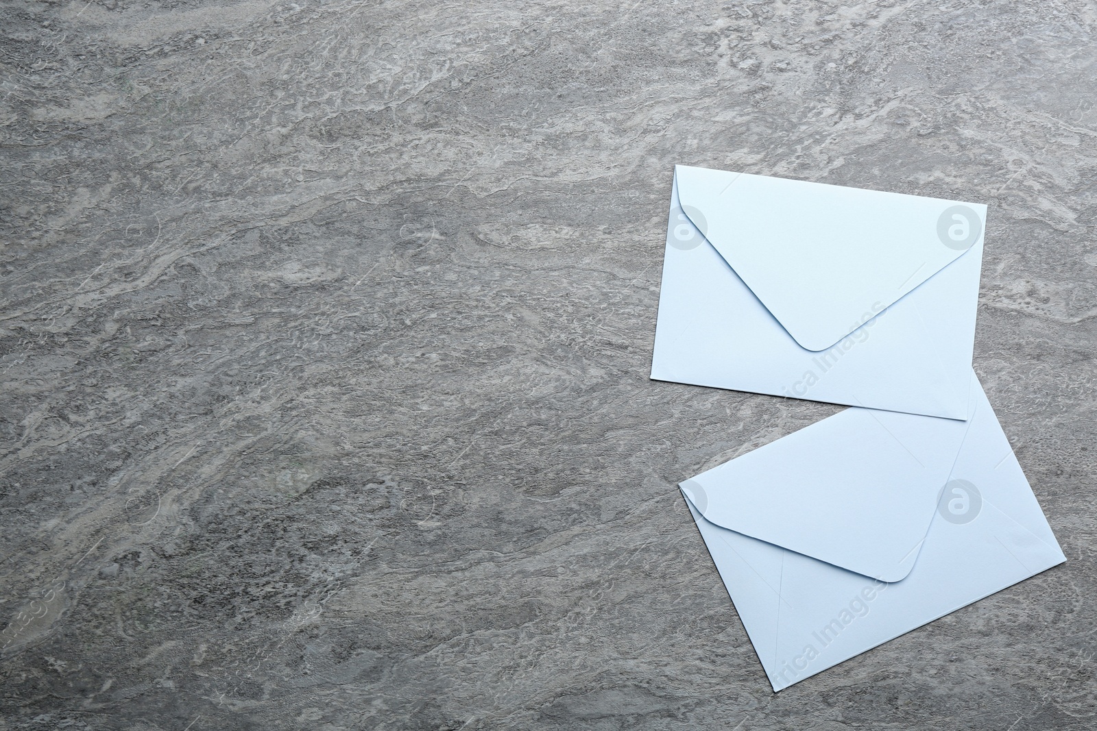 Photo of White paper envelopes on grey background, flat lay. Space for text