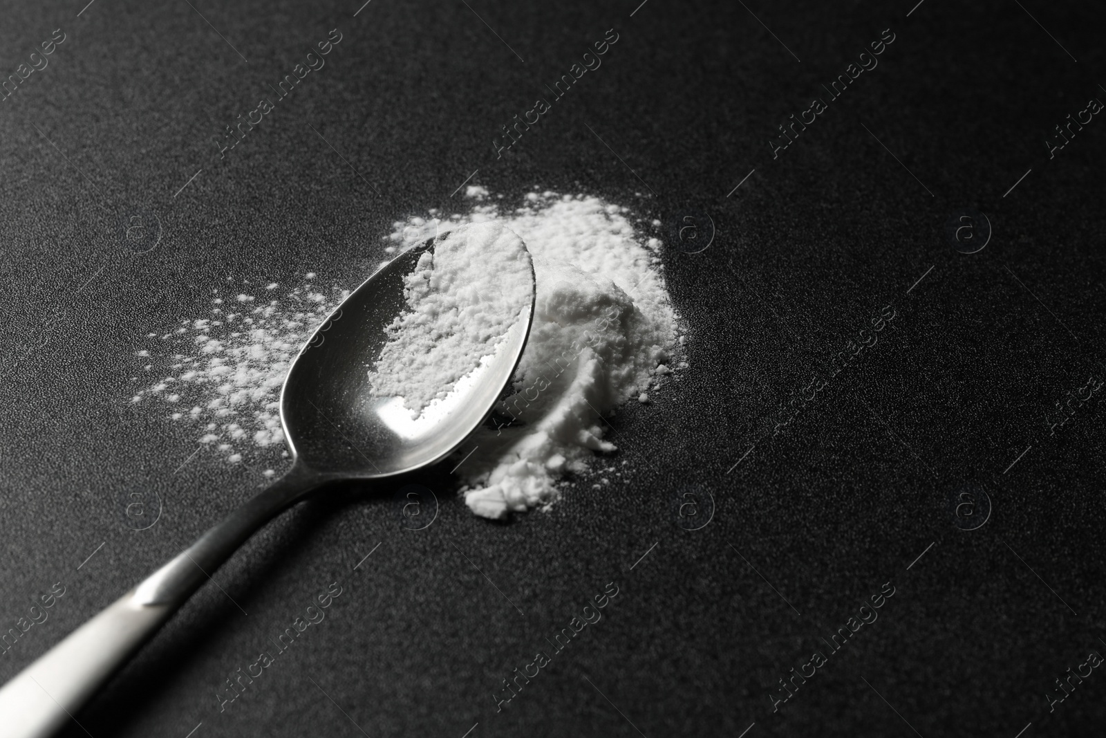 Photo of Spoon with cocaine powder on dark background. Space for text