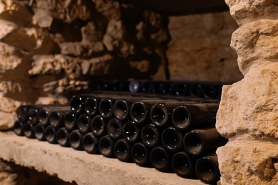 Photo of Many wine bottles on shelf in cellar