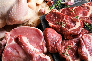 Closeup view of fresh raw meat and herbs on table